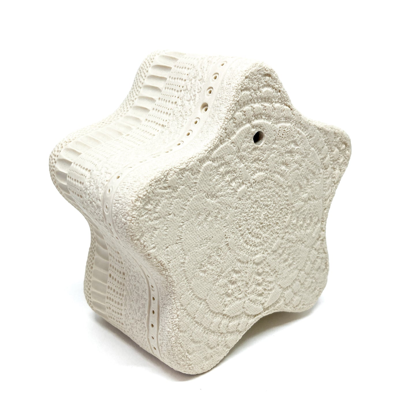 Uniformly textured star sculpture with an intricate, repeating surface design.