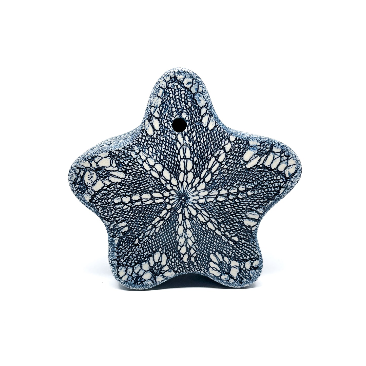 Top view of the Blue Oxide Diatom Star Sculpture, revealing a symmetrical, lace-like pattern and a central hole.