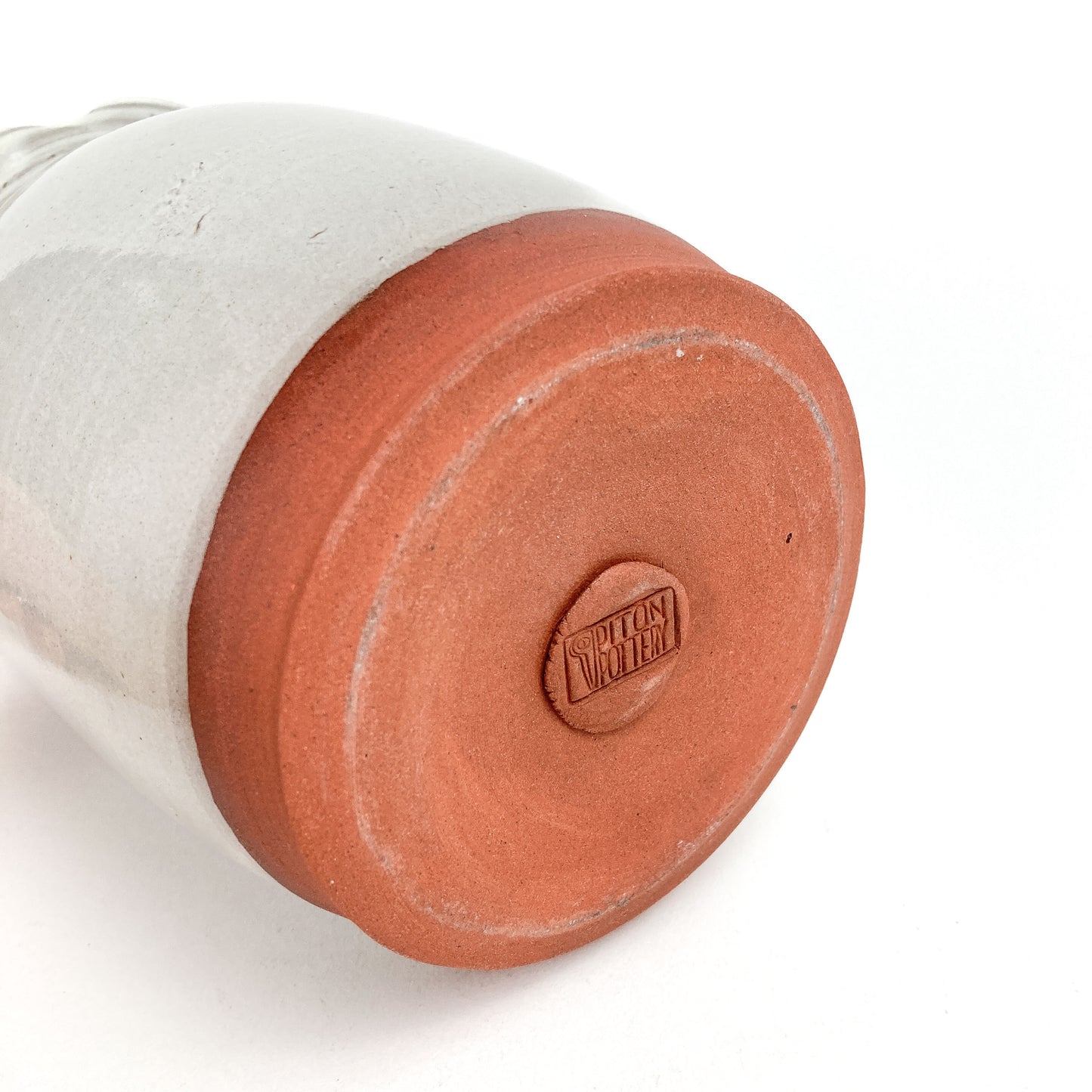 Bottom view of a Coral Patola Ripple Vase showing the unglazed base.