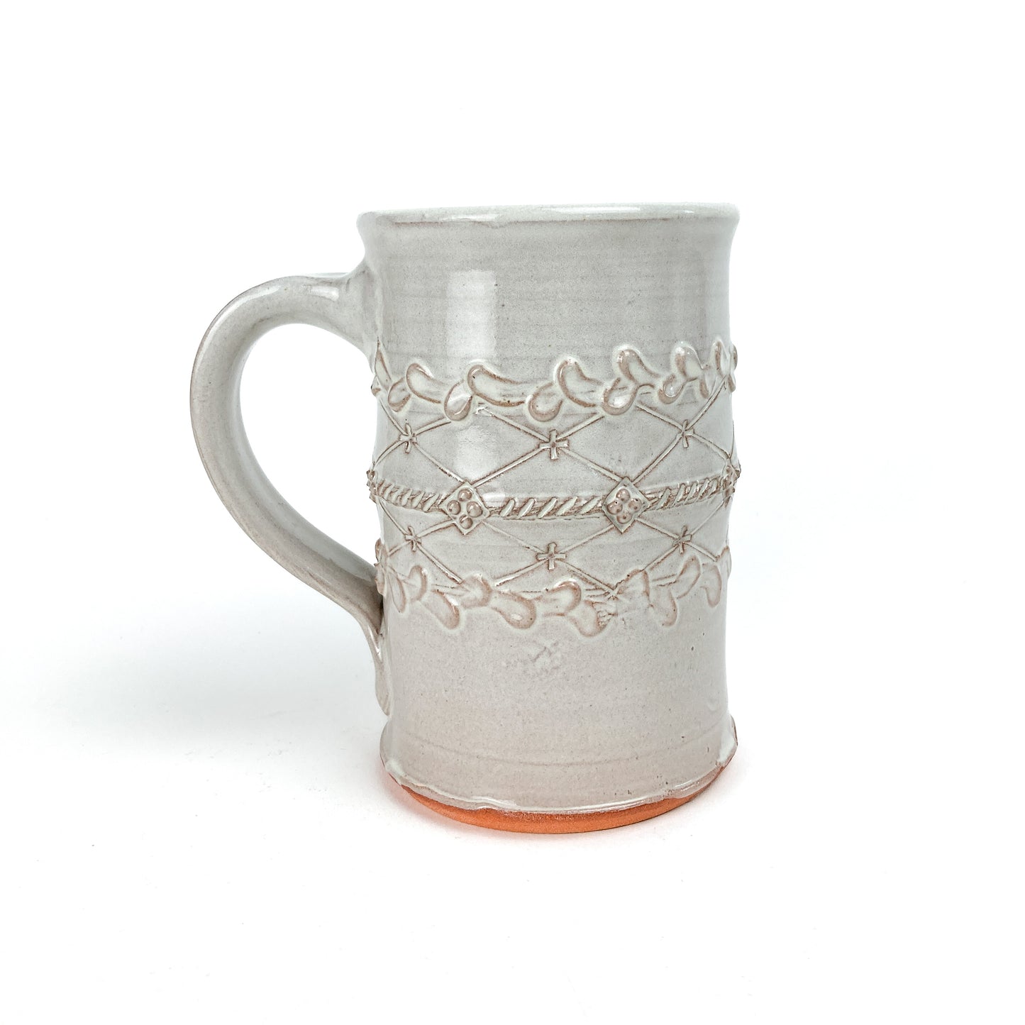 Ceramic Coral Patola Trellis Stein with a raised coral and garland design and visible unglazed base.