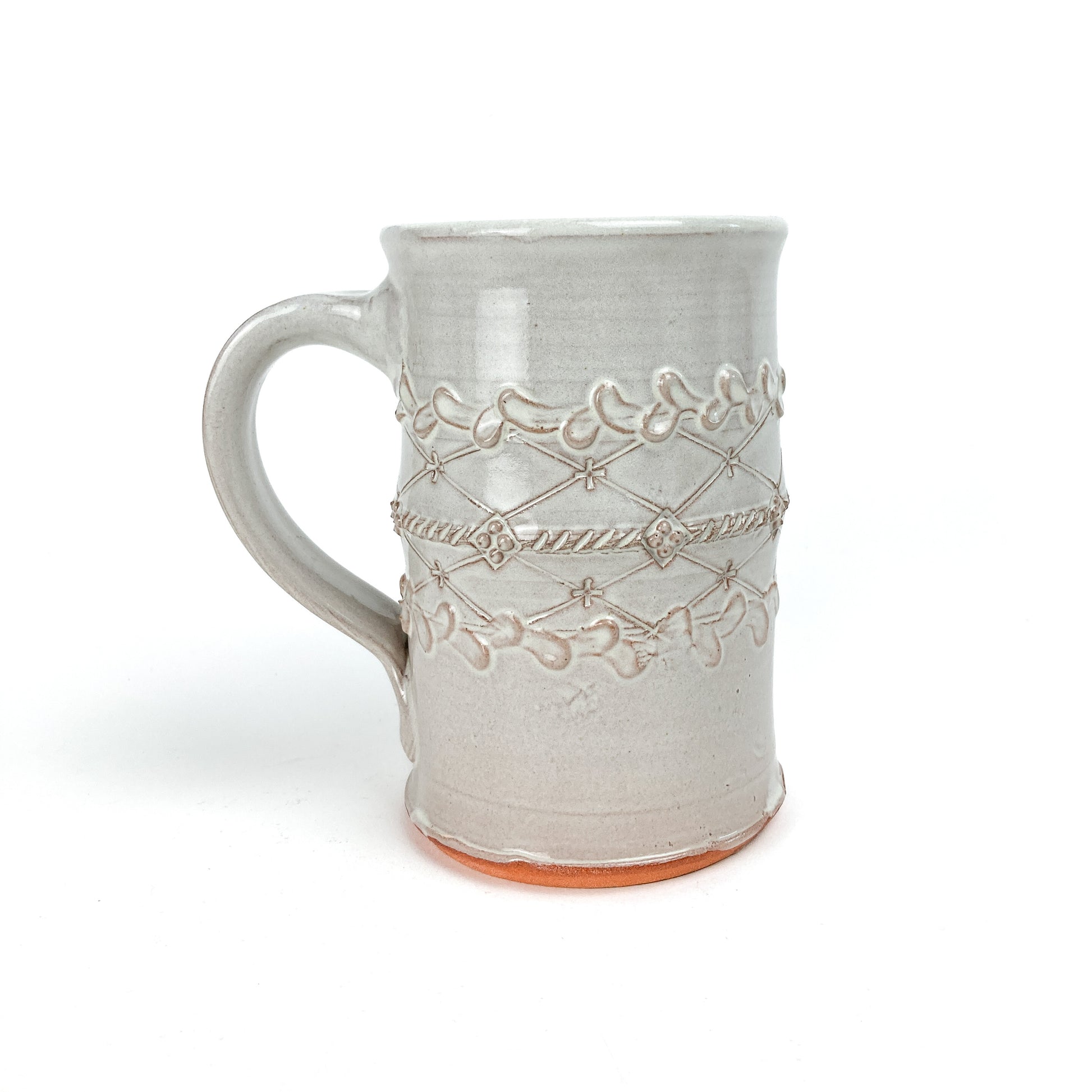 Ceramic Coral Patola Trellis Stein with a raised coral and garland design and visible unglazed base.