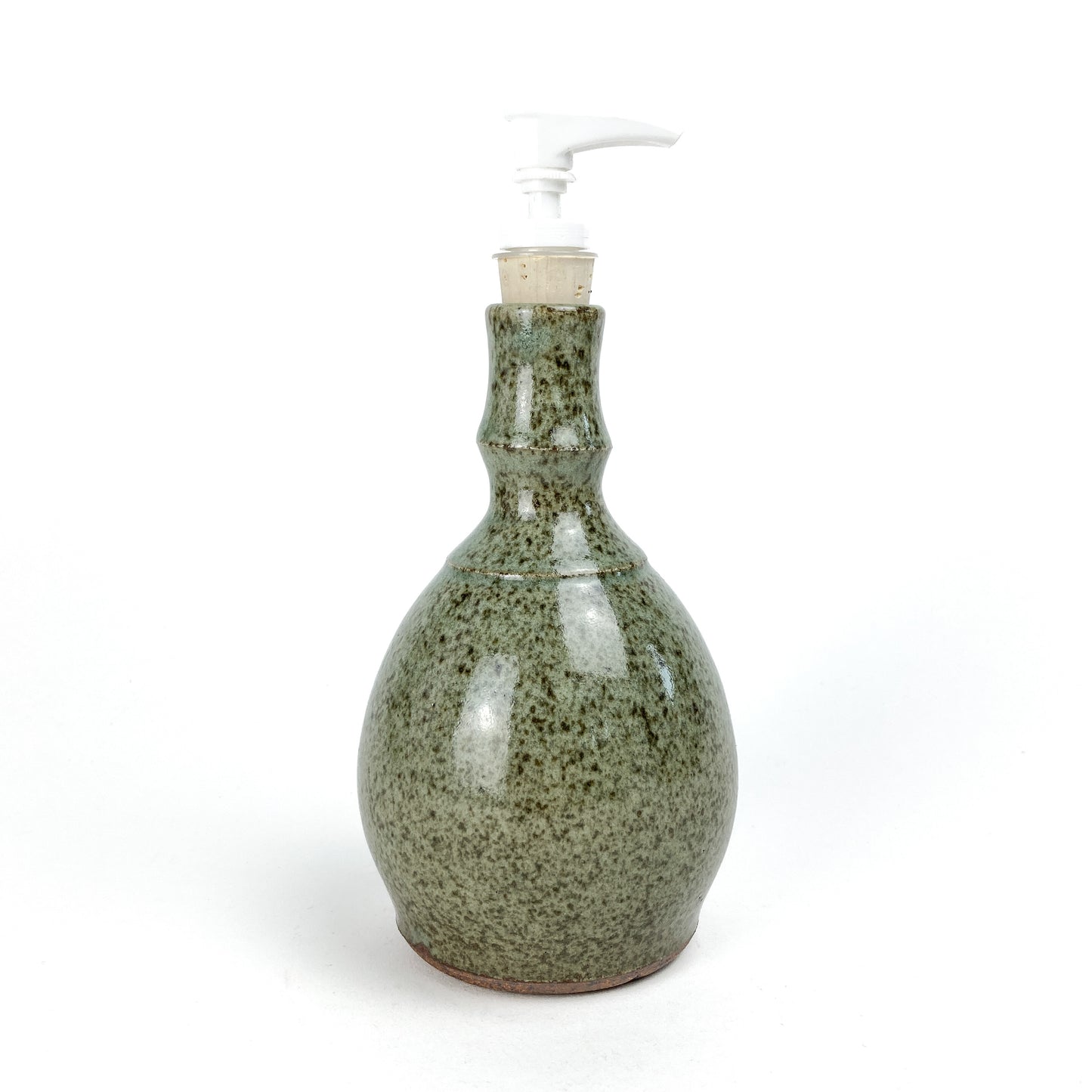 Coral Patola Celadon Pump Bottle, a textured ceramic dispenser with a white pump and unglazed base.