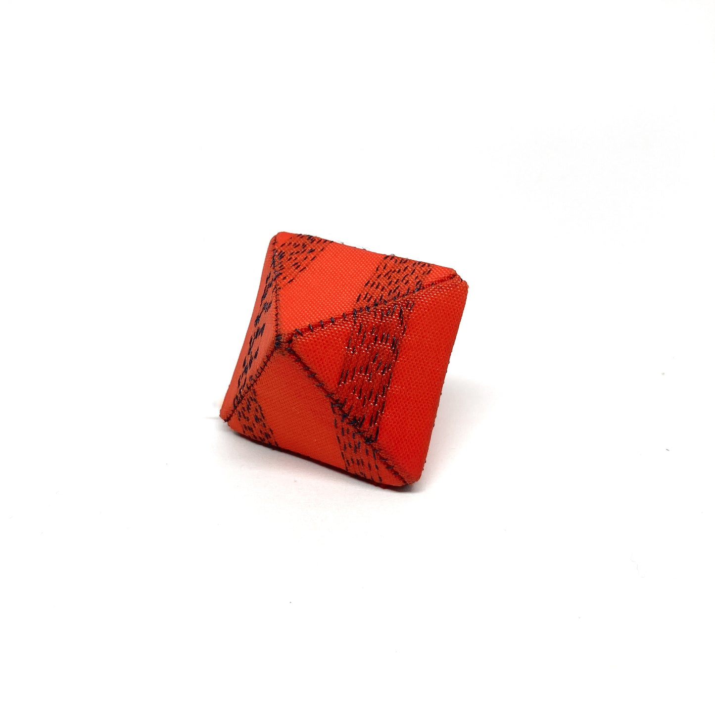 An orange Flagged Ring, a cube-like item with dark seams, is positioned against a plain backdrop