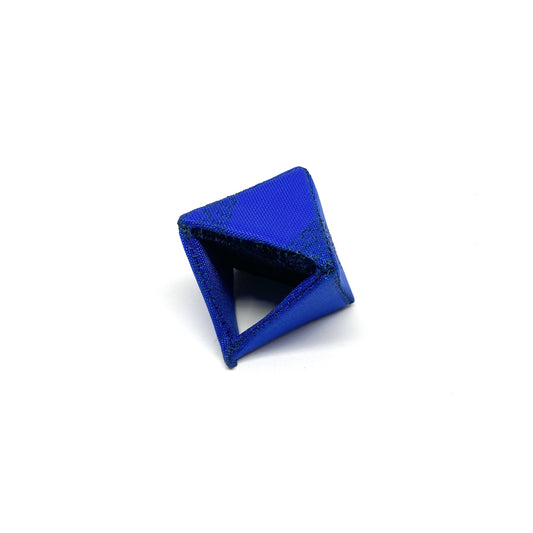 A Flagged Ring, a blue, triangular object with dark stitching, casting a shadow.