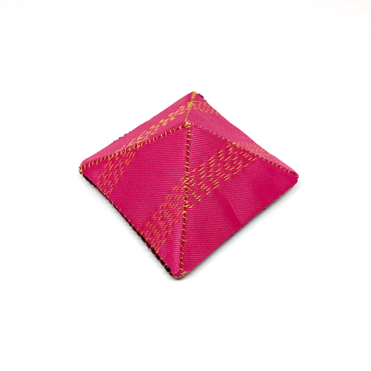 A square "Flagged Elevensies" brooch with textured fabric and stitched detailing.