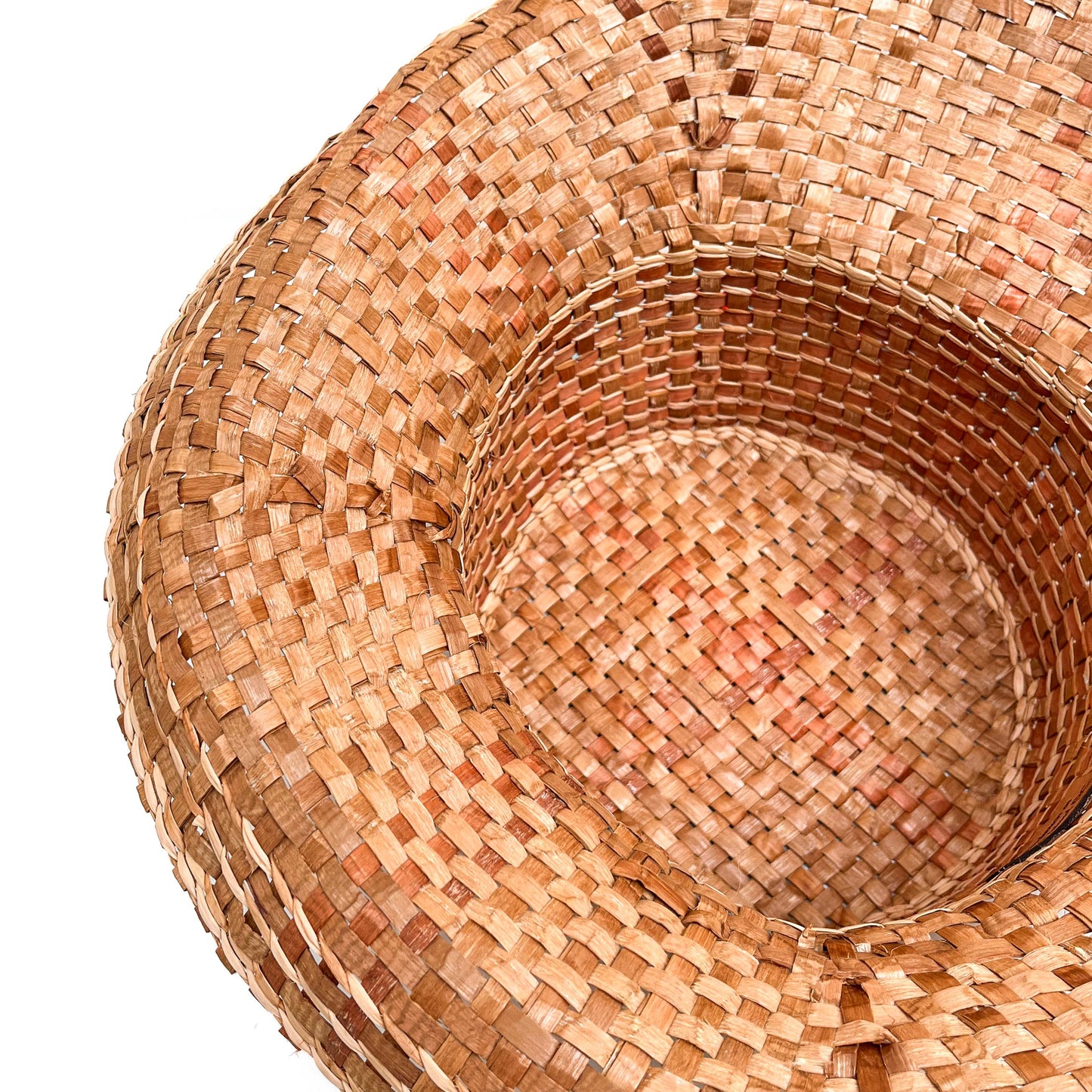 A close-up, angled view of the inside of a woven hat, showing the texture of the weave.