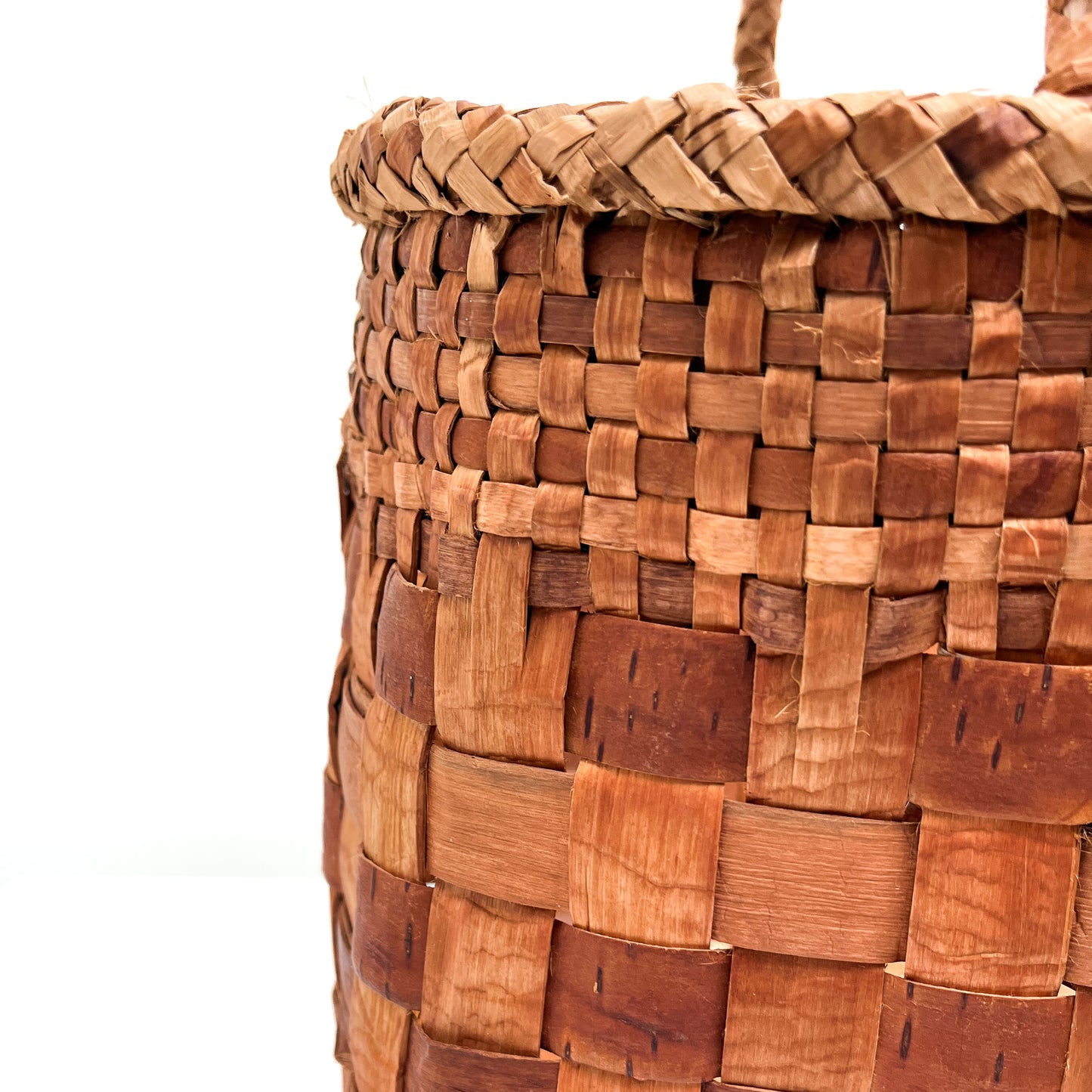 A close-up of a woven basket's edge, highlighting the checkered pattern and rim detail.