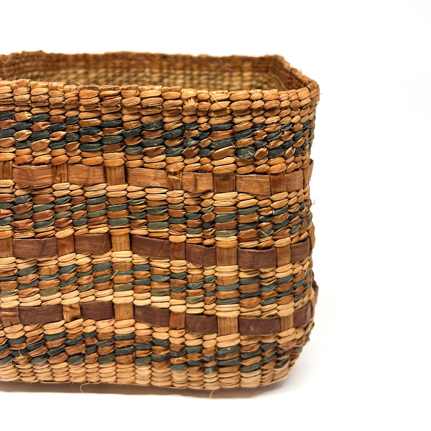 A close-up of a square woven basket with brown and dark blue horizontal stripes.
