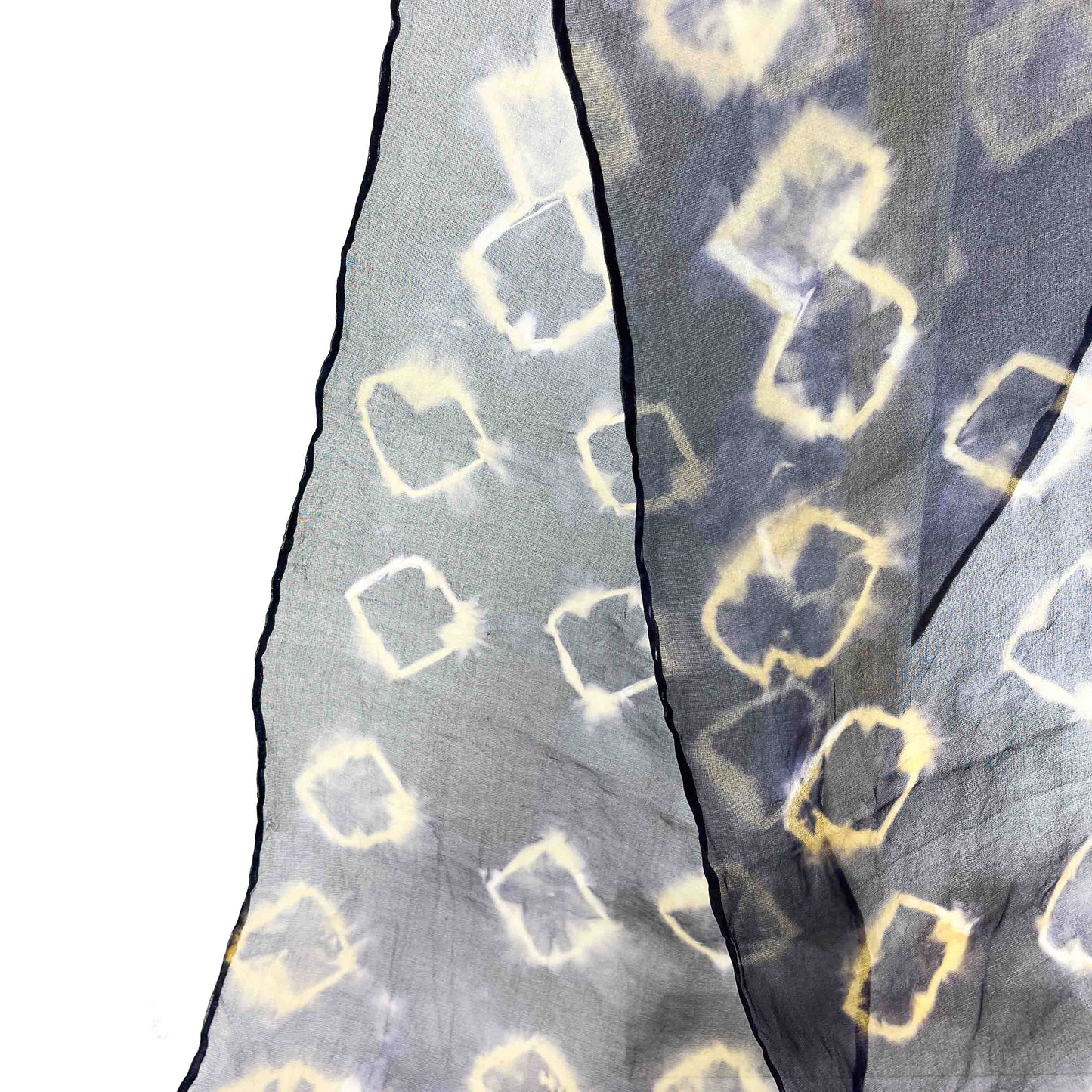 A close-up shows the delicate fabric and resist shibori pattern of a Black Bean Hull silk scarf with outlined squares.