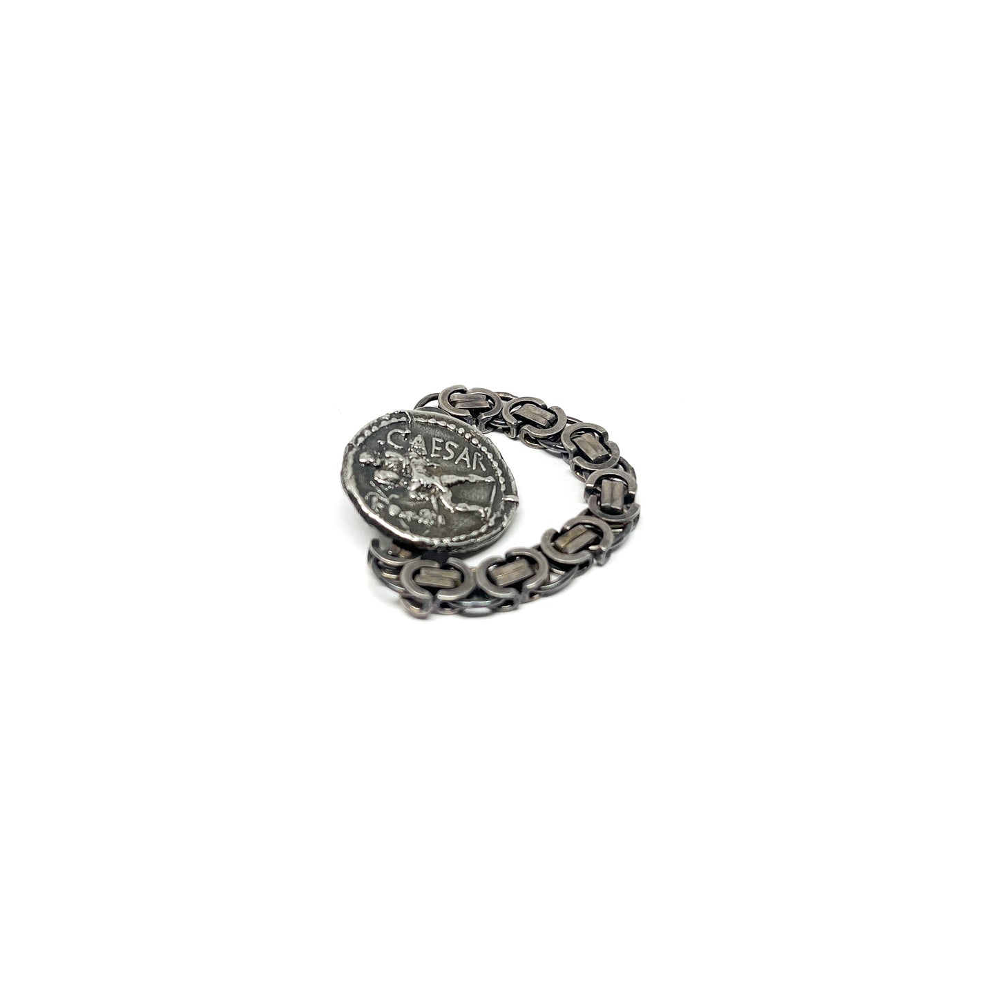 A silver ring with a chain band and a detailed, antique coin featuring the inscription ".CAESAR" and a figure.