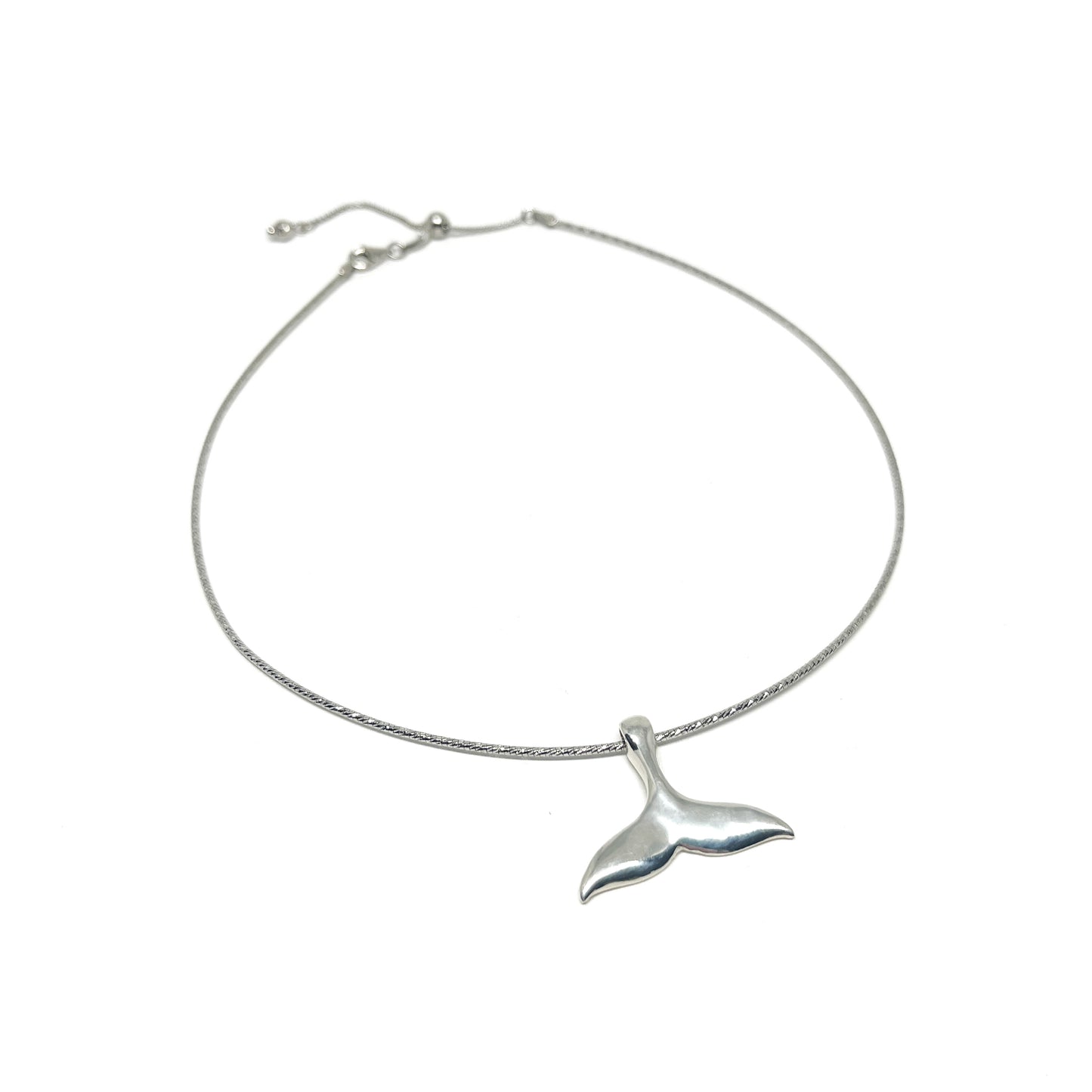 A silver anklet featuring a polished whale tail pendant on a delicate, adjustable chain.
