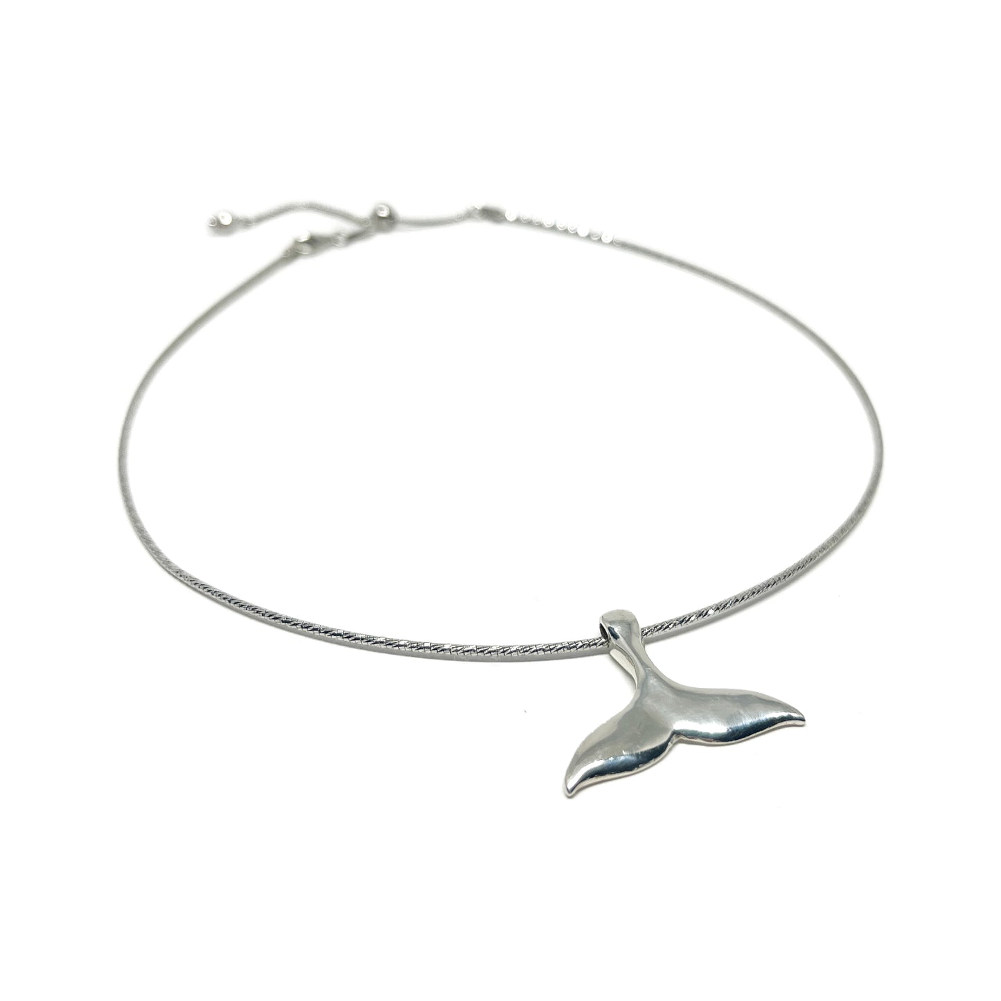 A silver anklet featuring a polished whale tail pendant on a delicate, adjustable chain.