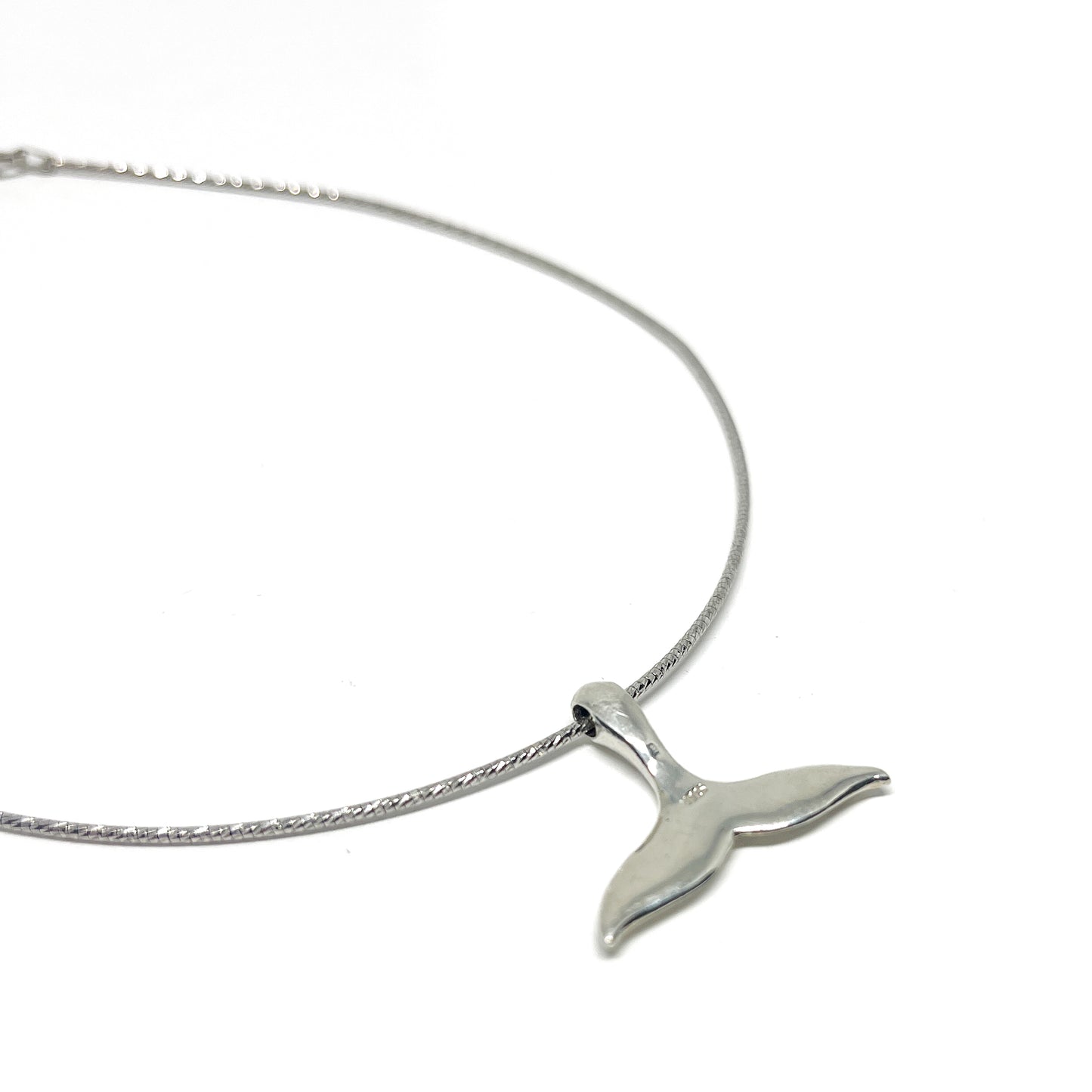 A delicate silver necklace featuring a polished Sterling Silver Whale Tail Pendant on a fine chain.
