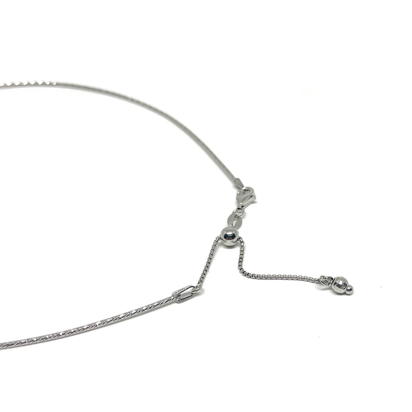 Close-up of the clasp and adjustable chain of a delicate silver necklace with small spherical accents.