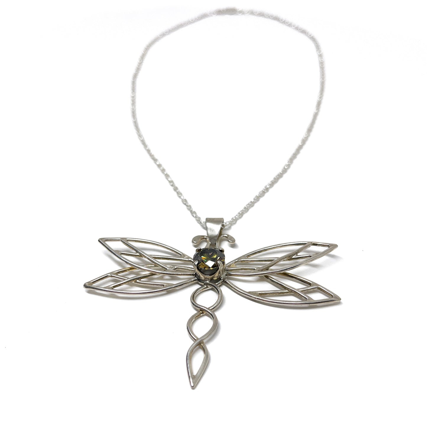 Detailed view of a silver dragonfly pendant necklace featuring a central dark gemstone.