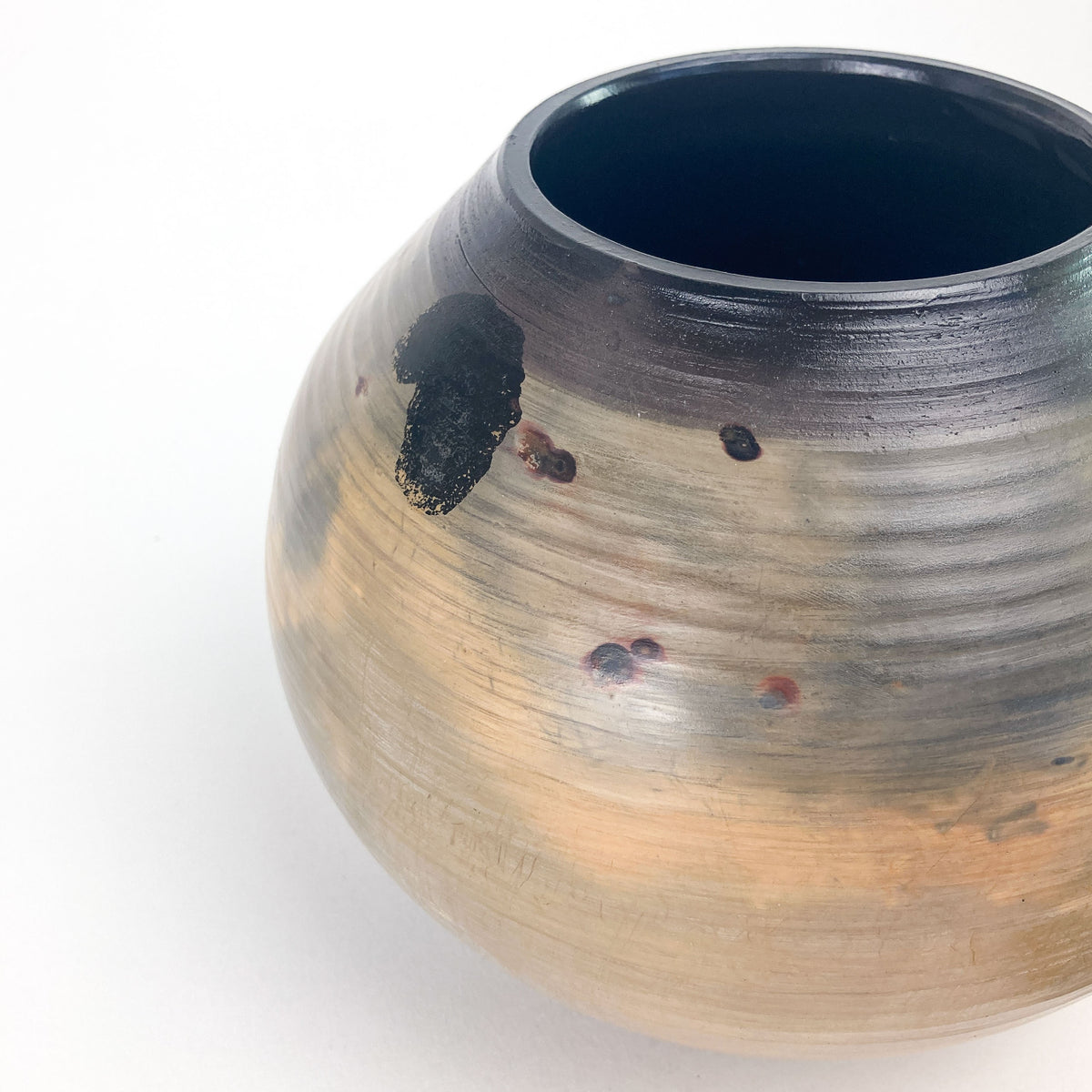 Handmade ceramic jar with coil spring lid and textured surface.