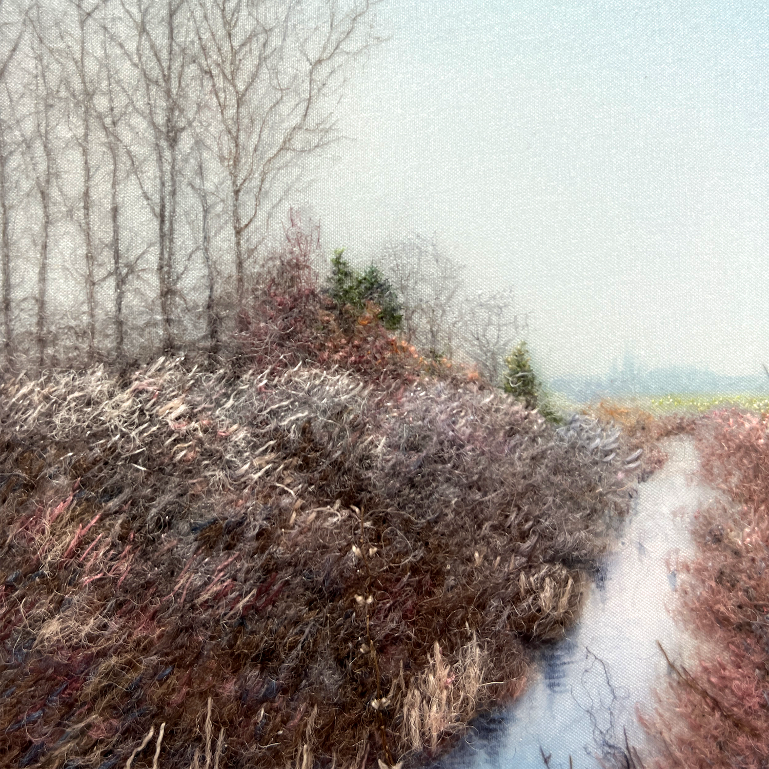 Close-up of the "Into the Blue" Embroidered Wall Art, showing intricate details of shrubs, trees, and a waterway.