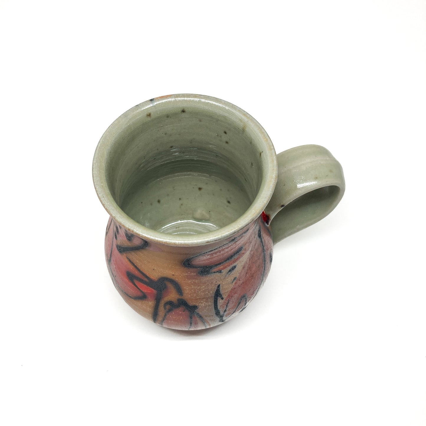 A ceramic mug with a handle, viewed from above, showing a hand-painted floral design on its exterior. The mug has a smooth, glazed finish.