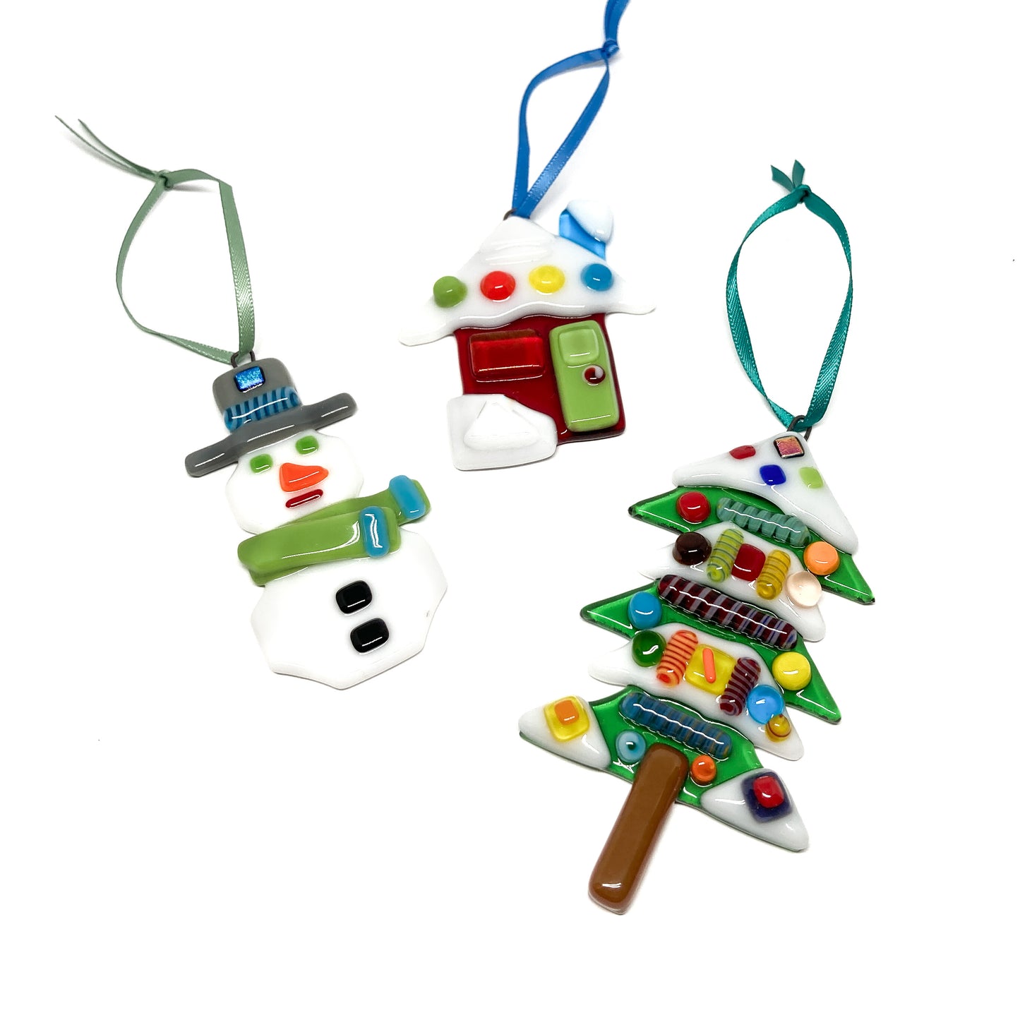 Three glass ornaments: snowman, house, and tree, with colorful details and ribbons.