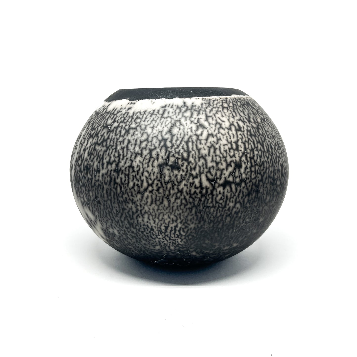 Round ceramic vase with a textured, crackled black and white glaze and a black rim.