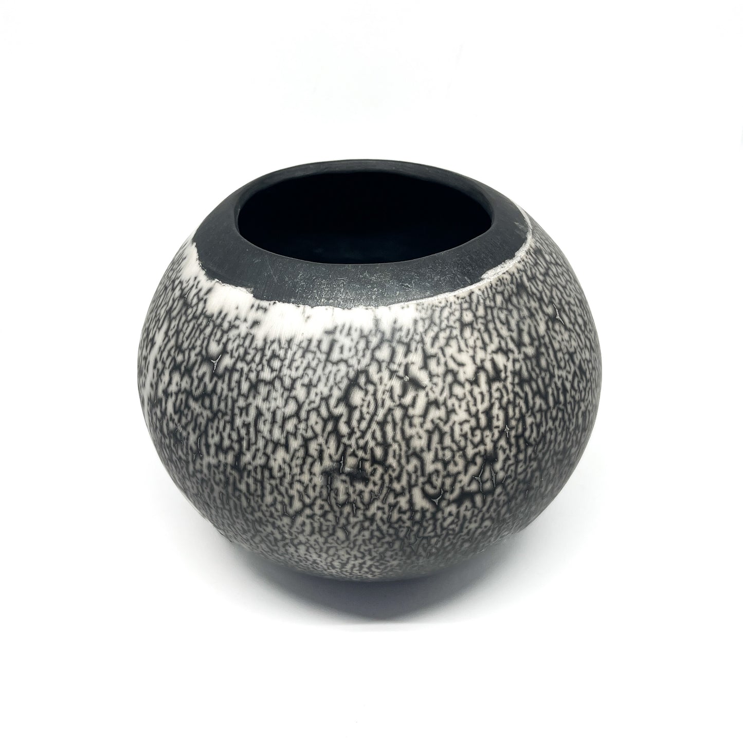 Round ceramic vase with a crackled black and white glaze and a contrasting black interior and rim.