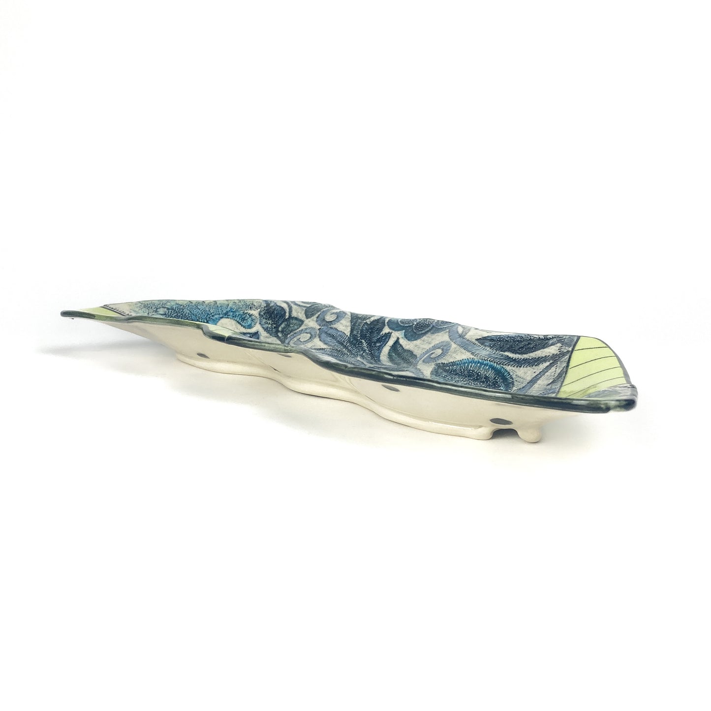 Top-down view of the Peapod Platter featuring botanical blue motifs and bold segmented green sections.