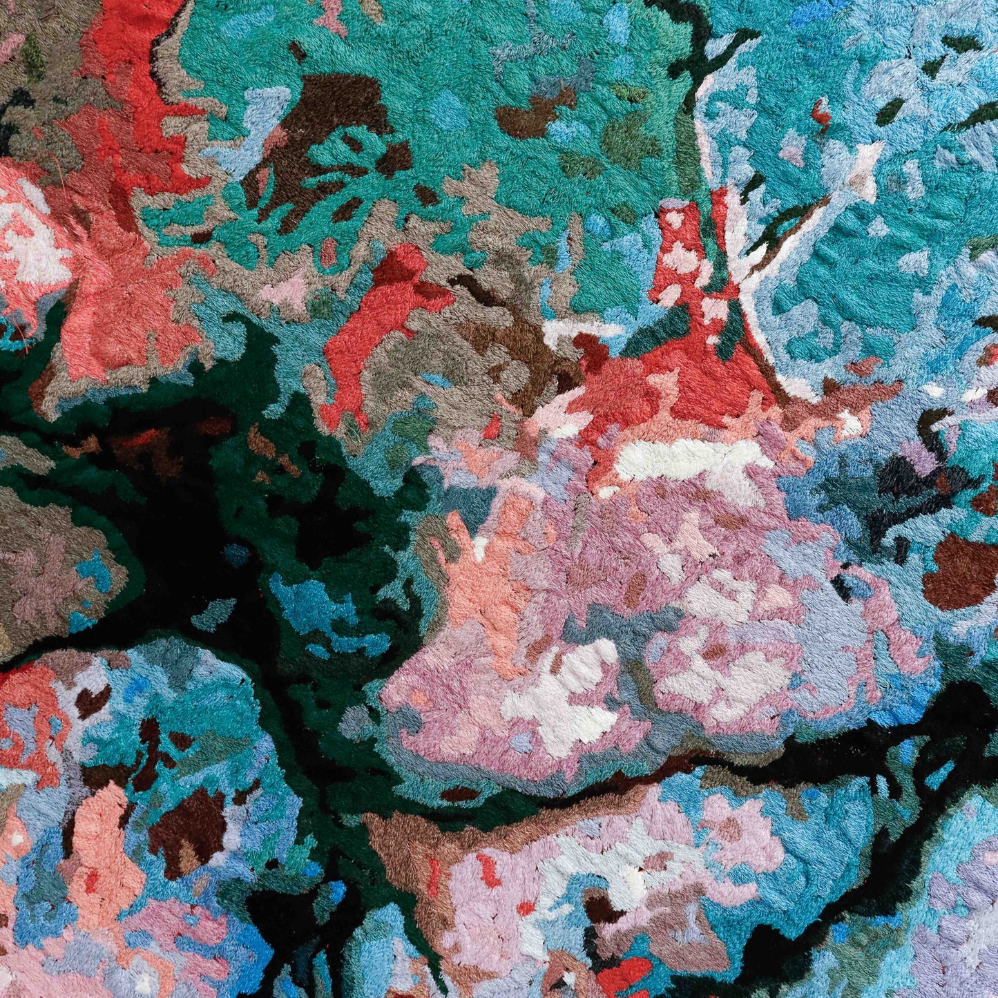 Close-up thread painting with intricate stitching. Abstract design formed with colorful thread in a textured embroidery.