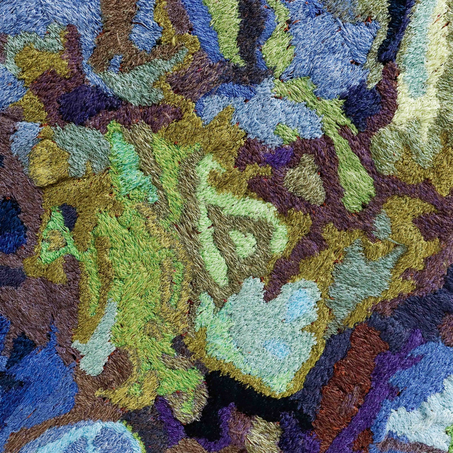 A close-up of a thread painting, showcasing intricate stitching and colorful thread in an abstract thread painting.