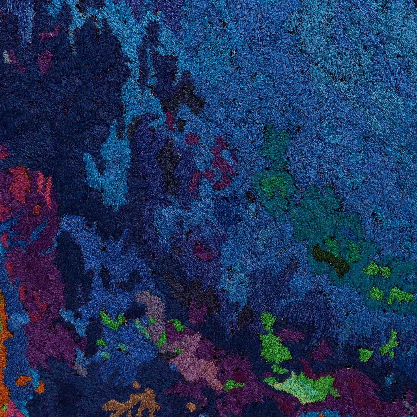 A close-up of a thread painting, showcasing intricate stitching and colorful thread in an abstract thread painting.