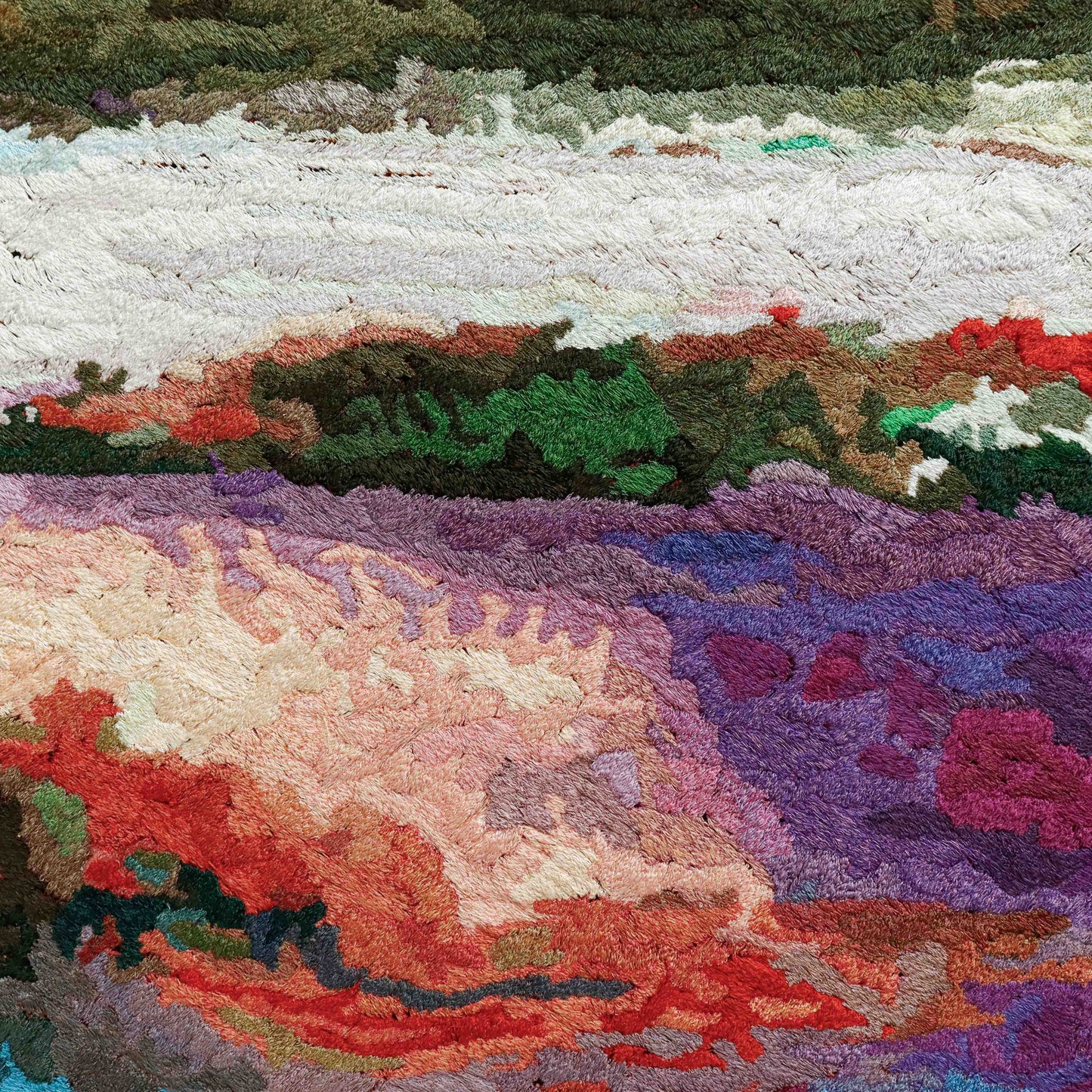 A close-up of a thread tapestry with an abstract landscape design, showcasing intricate stitching and colorful thread.