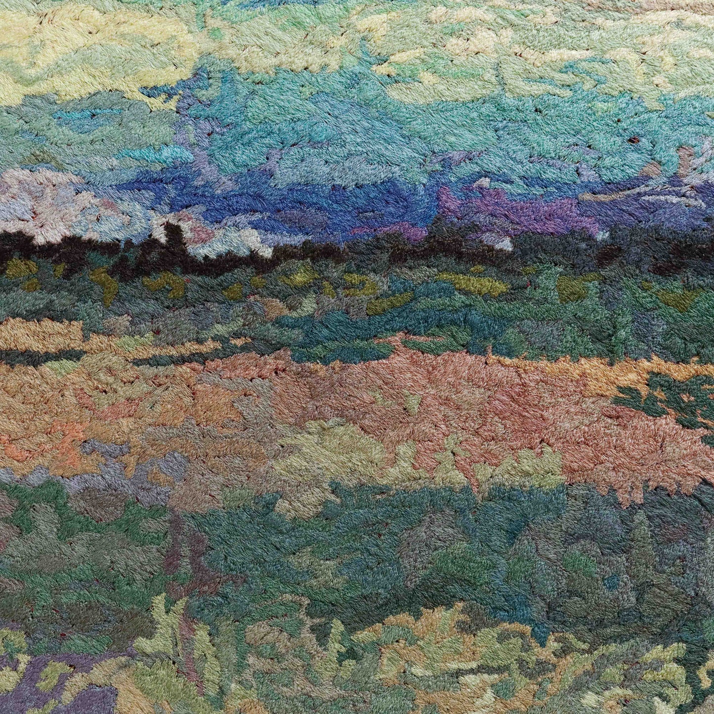 A close-up of a thread tapestry with a landscape design, showcasing intricate stitching and colorful thread.