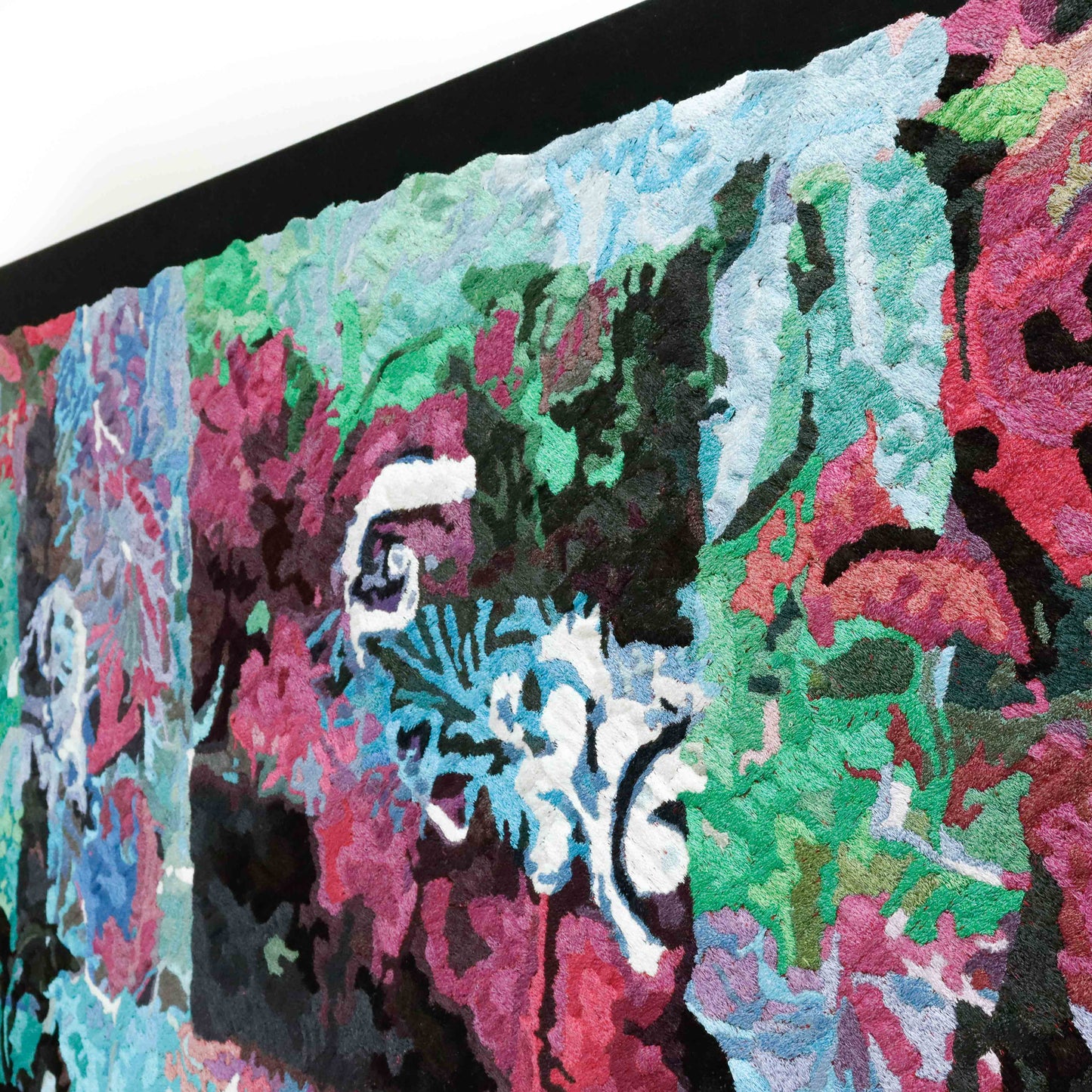 A framed thread tapestry, angled view, displaying intricate stitching and colorful thread in an abstract thread painting.