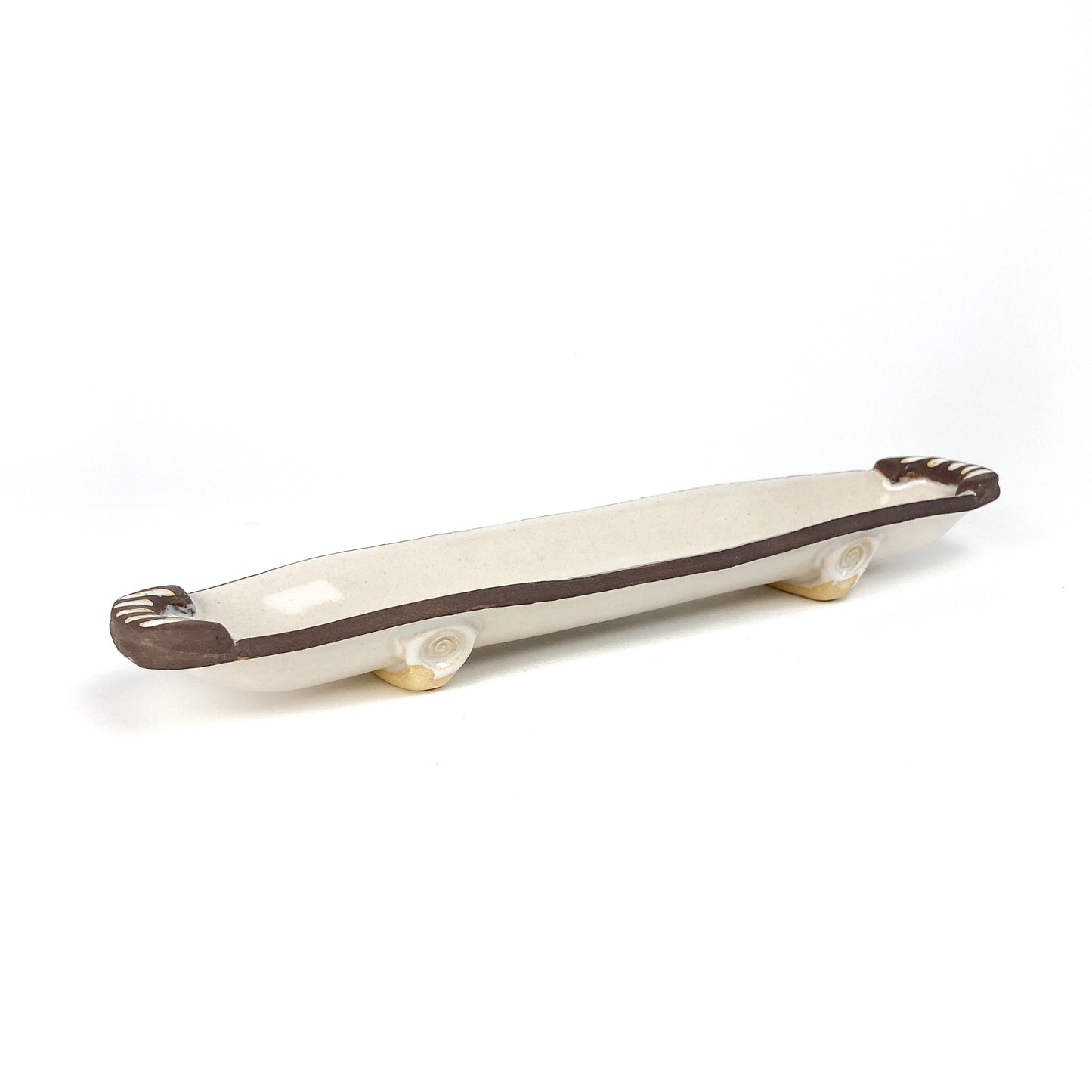 A long, narrow olive dish with raised details at each end.