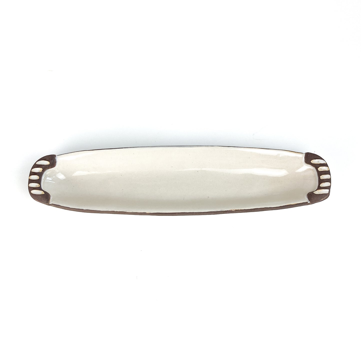 A long, narrow olive dish with raised details at each end.
