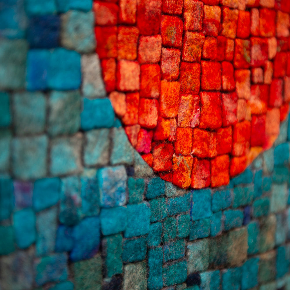 Close-up of a textured mosaic. Small squares form a gradient, partially obscured by an orange circle.