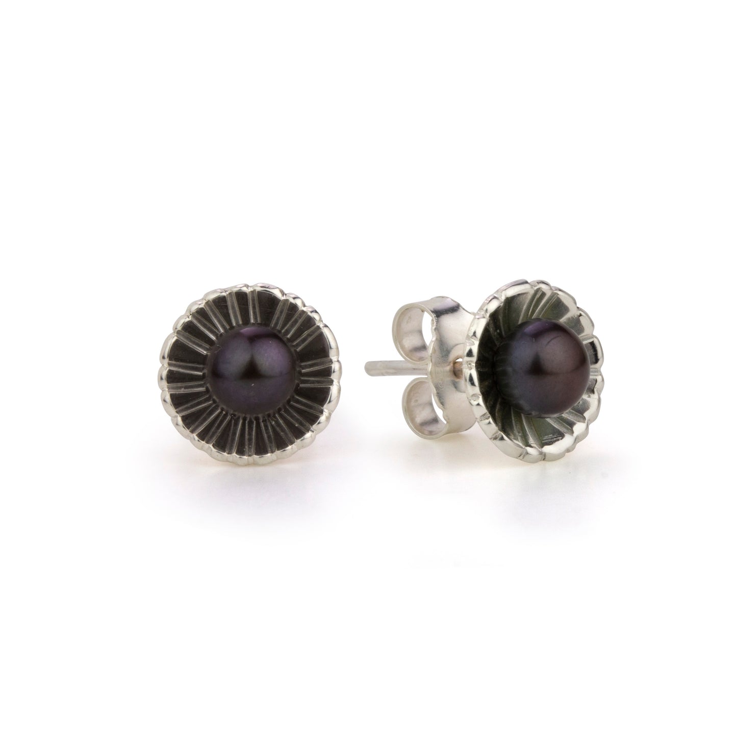 Two pearl stud earrings, each featuring a dark pearl in a textured, scalloped silver setting.