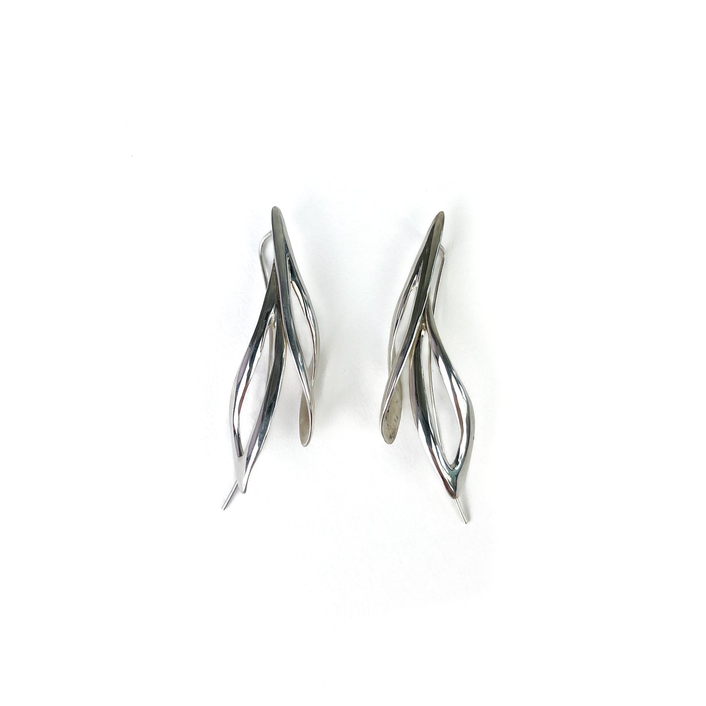 Pair of shiny silver willow earrings, angled view showing their curved, open design.