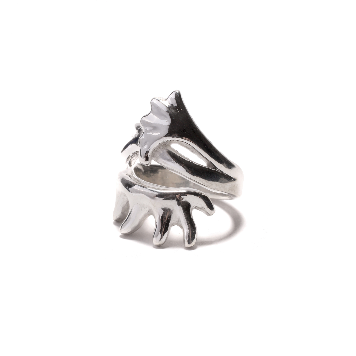 A shiny silver ring with a stylized, branching design resembling deer antlers wraps around the finger.