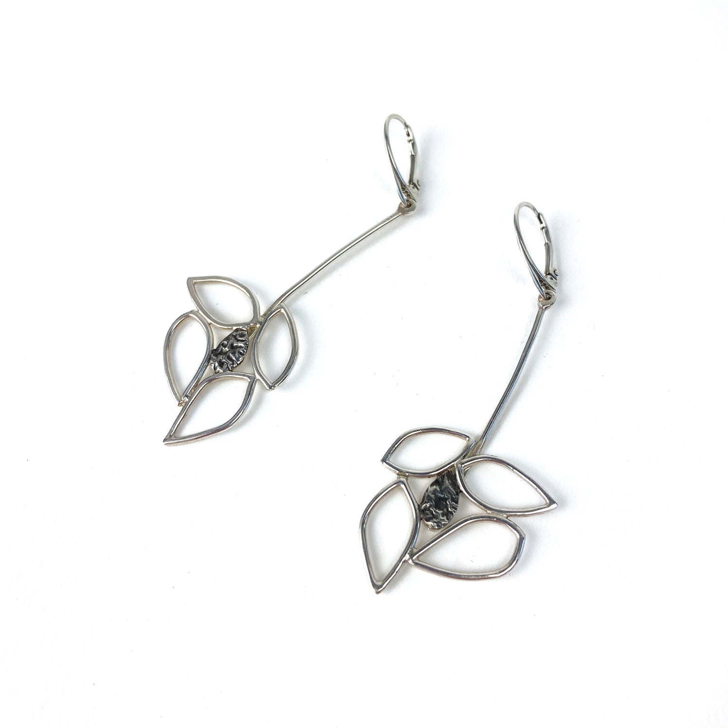 Close-up of two silver Dogwood Drops earrings with delicate leaf shapes and detailed centers.