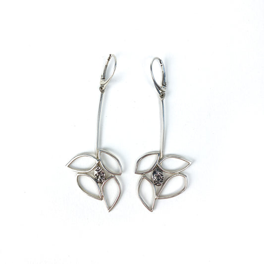 Two silver Dogwood Drops earrings with textured centers hang against a plain background.