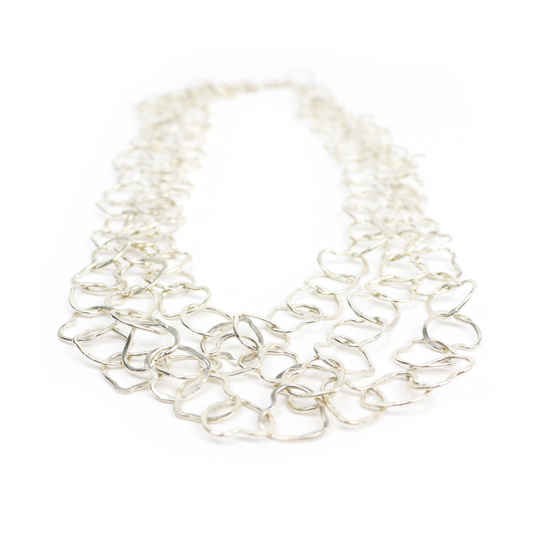 Heart Necklace featuring multiple hand-formed silver heart links arranged in a layered design.