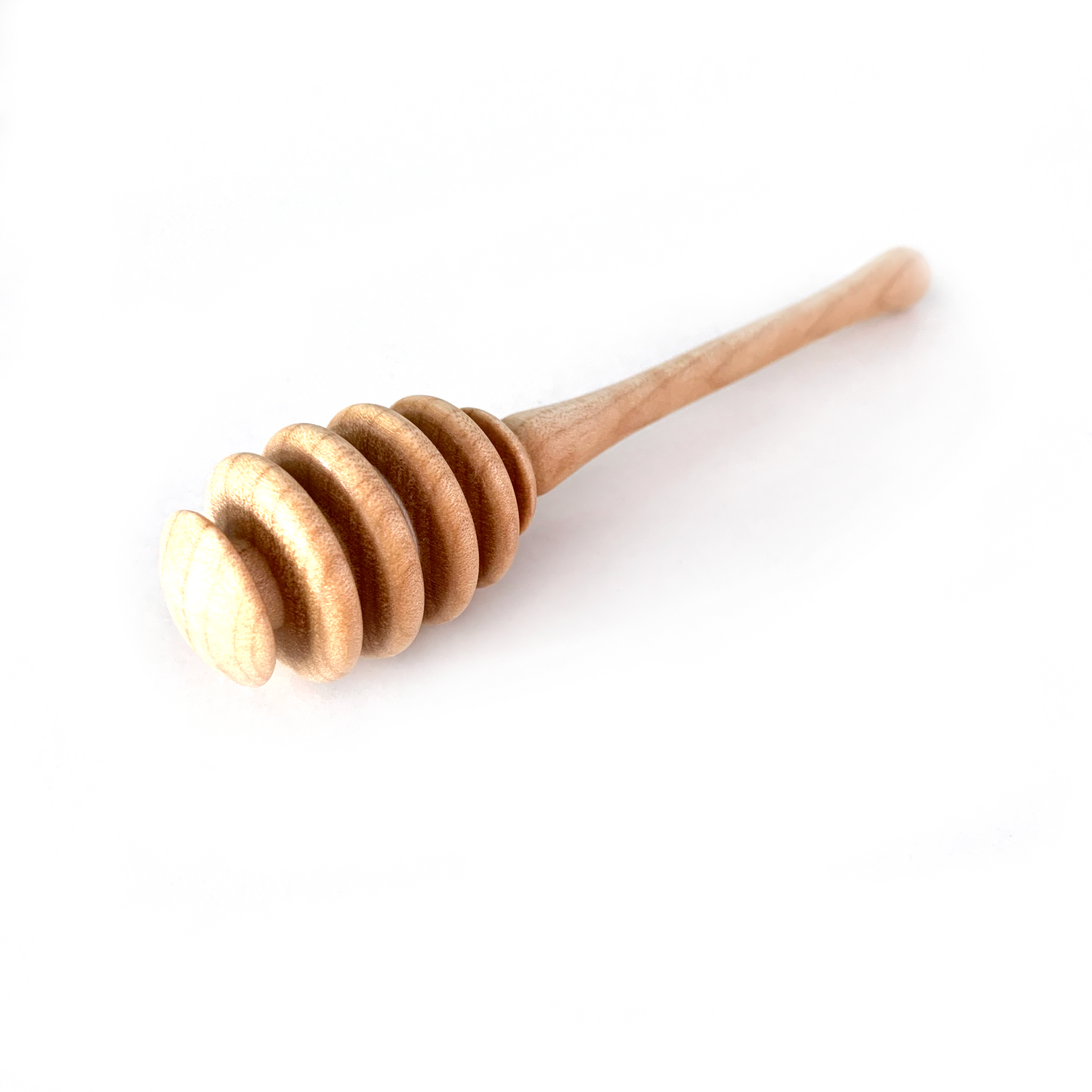 A light wooden honey dipper with a grooved head.