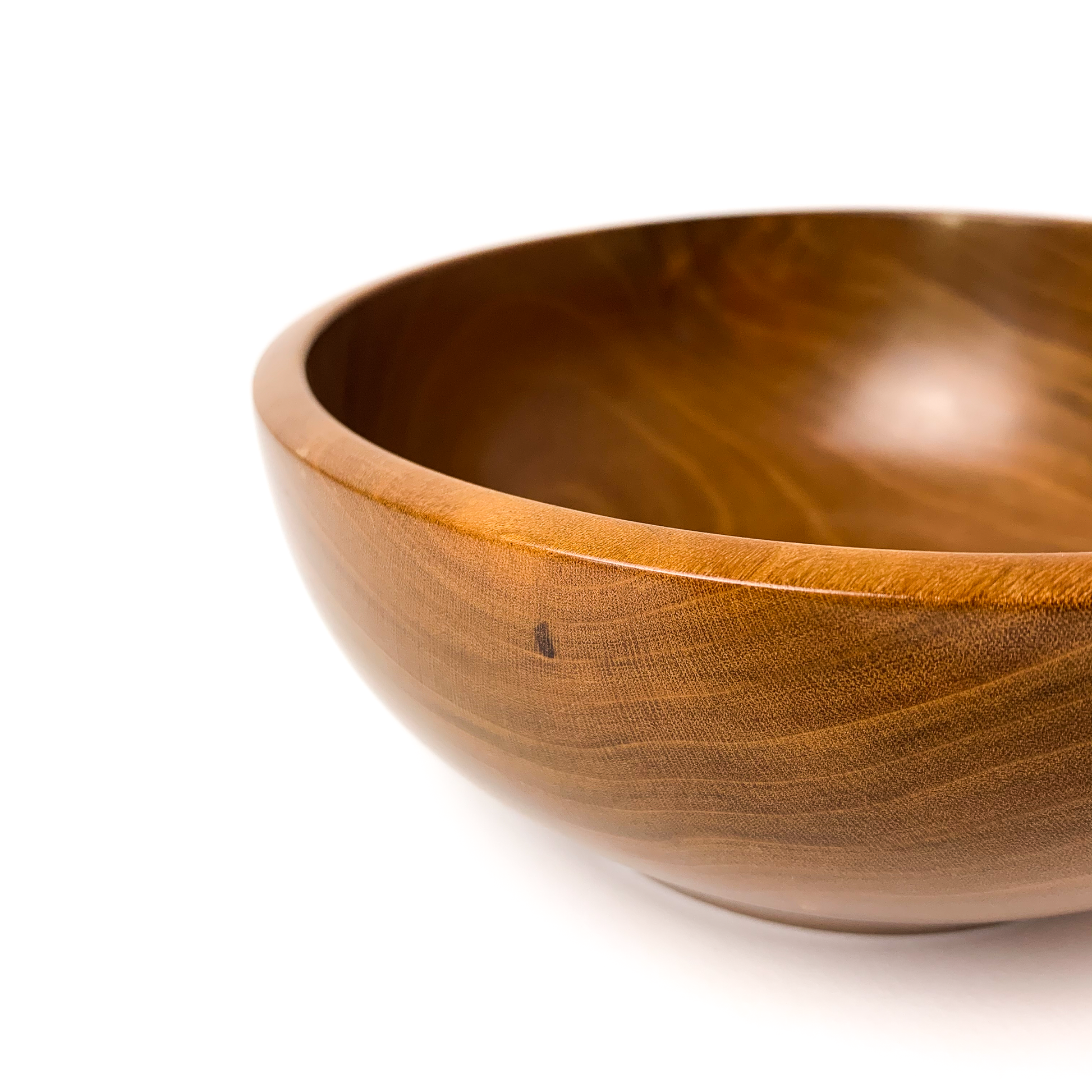 A brown wooden bowl with a smooth, rounded exterior, close-up angled view.