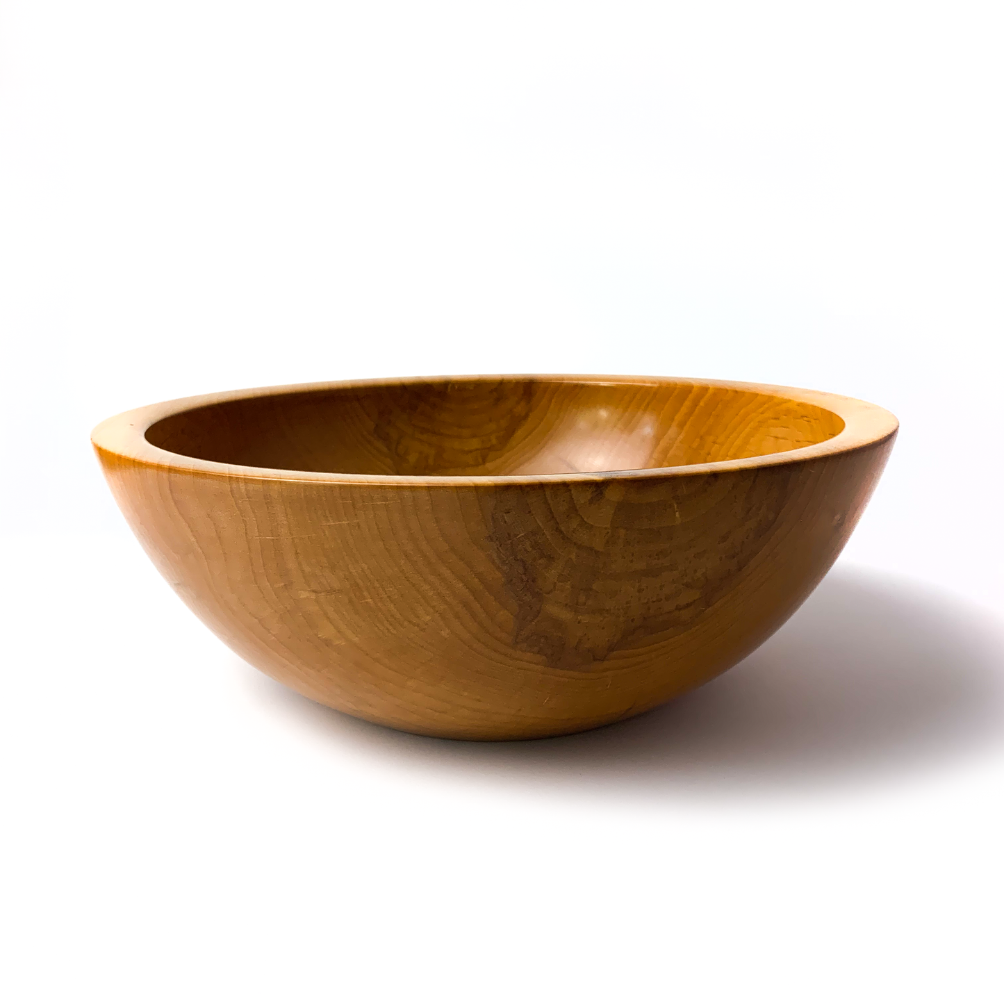 A light brown maple salad bowl with a smooth, rounded interior.