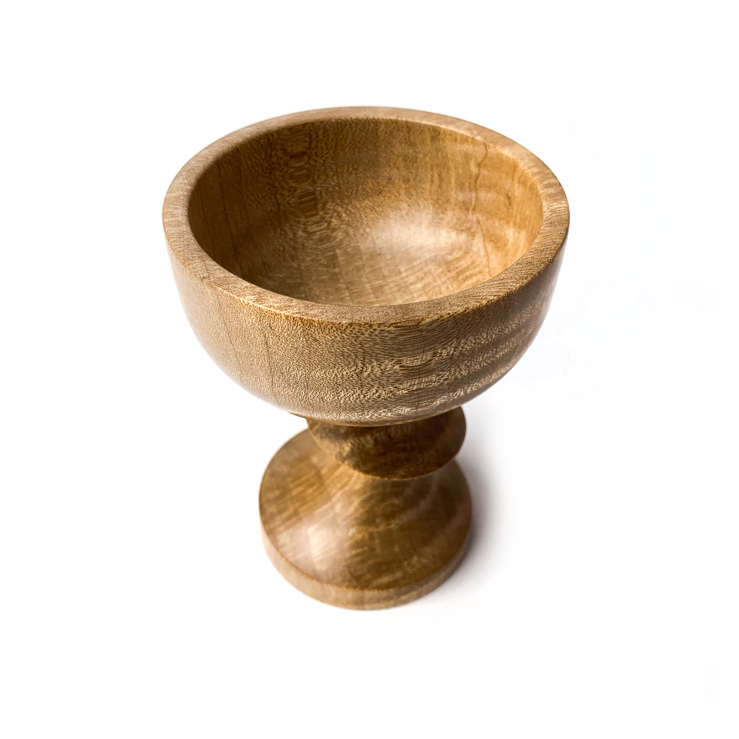 A light brown maple goblet with a rounded bowl and short stem.