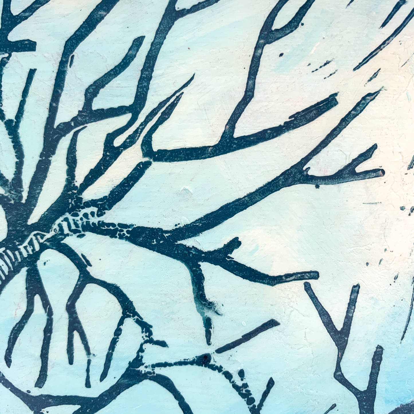 Close-up of a tree branch linocut print on a wood panel wall hanging, showcasing texture and detail.