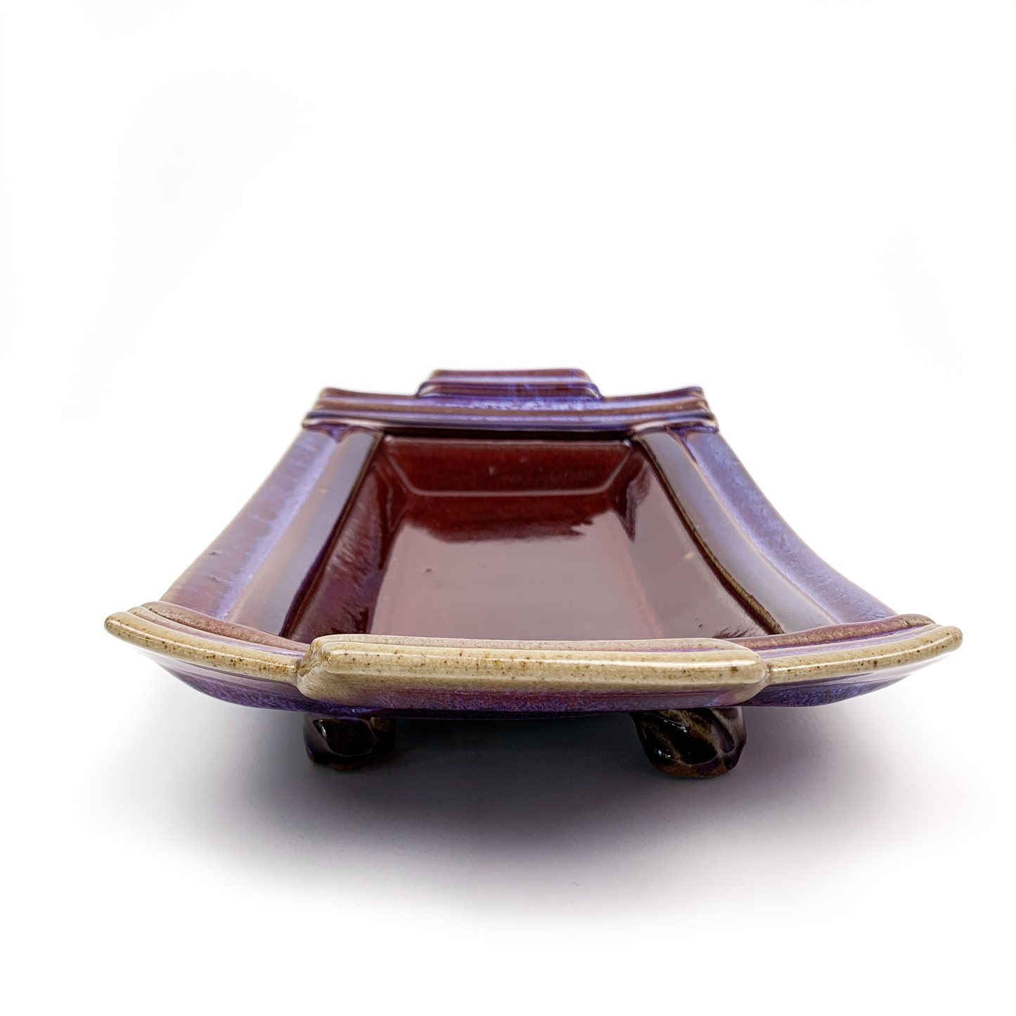 A square, ceramic bonsai pot with a glossy purple glaze and small feet.