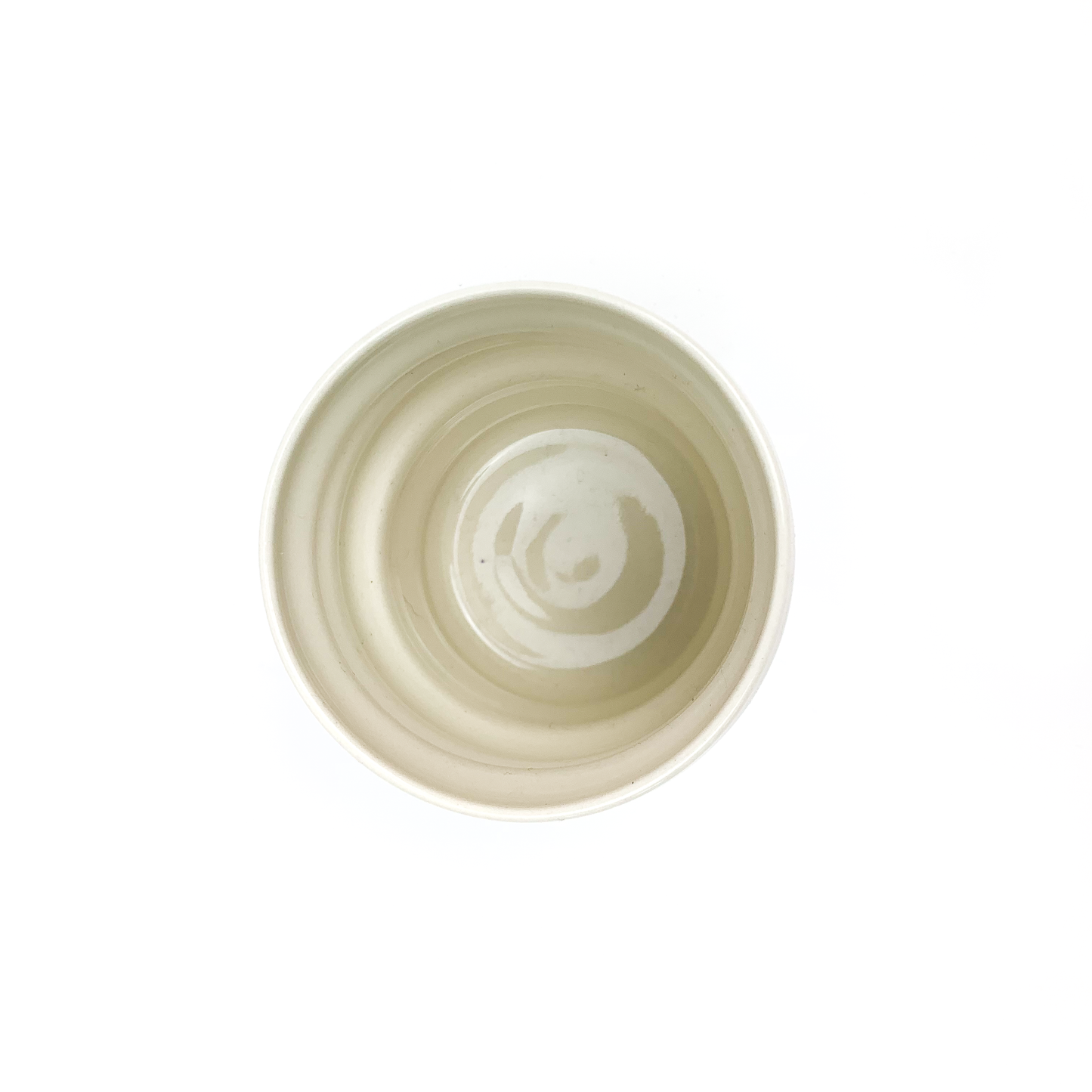 Top-down view of a round ceramic cup with concentric rings visible on its inner surface.