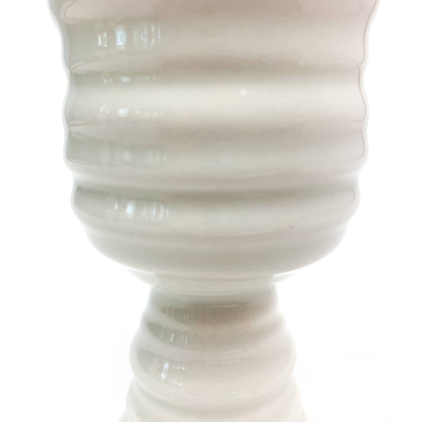 Close-up of the textured surface of a ceramic pedestal with horizontal rings, showing subtle variations in the material.