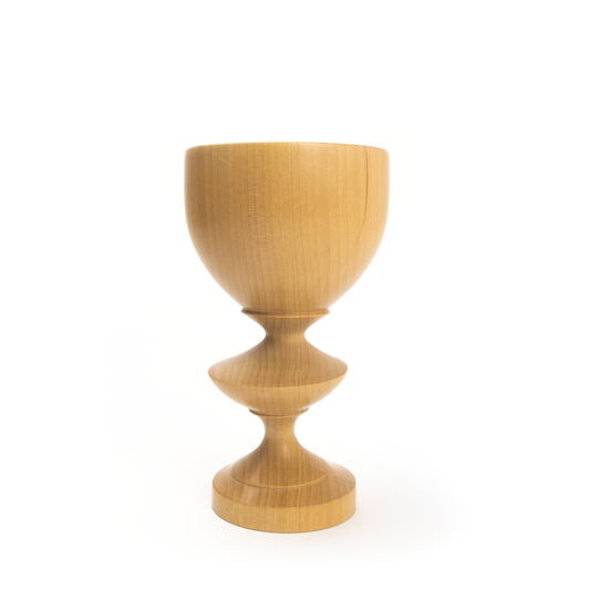 A light brown wooden goblet with a rounded bowl and a twisted stem.